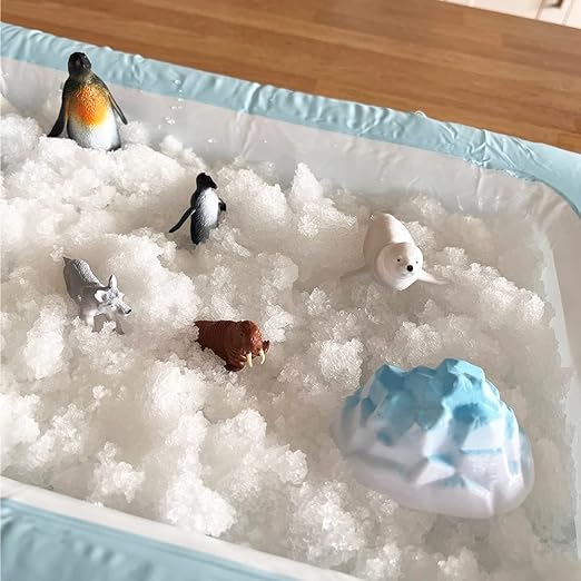 Enfant jouant avec la neige sensorielle et les animaux arctiques Zimpli